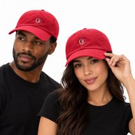 Man and woman modeling red CJC embroidered baseball caps, with the woman holding her brim and the man looking to the side.