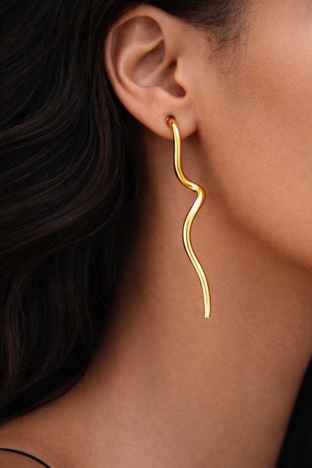 Model wearing Flow Gold Sculptural earrings, showcasing polished gold finish and modern sculptural silhouette.