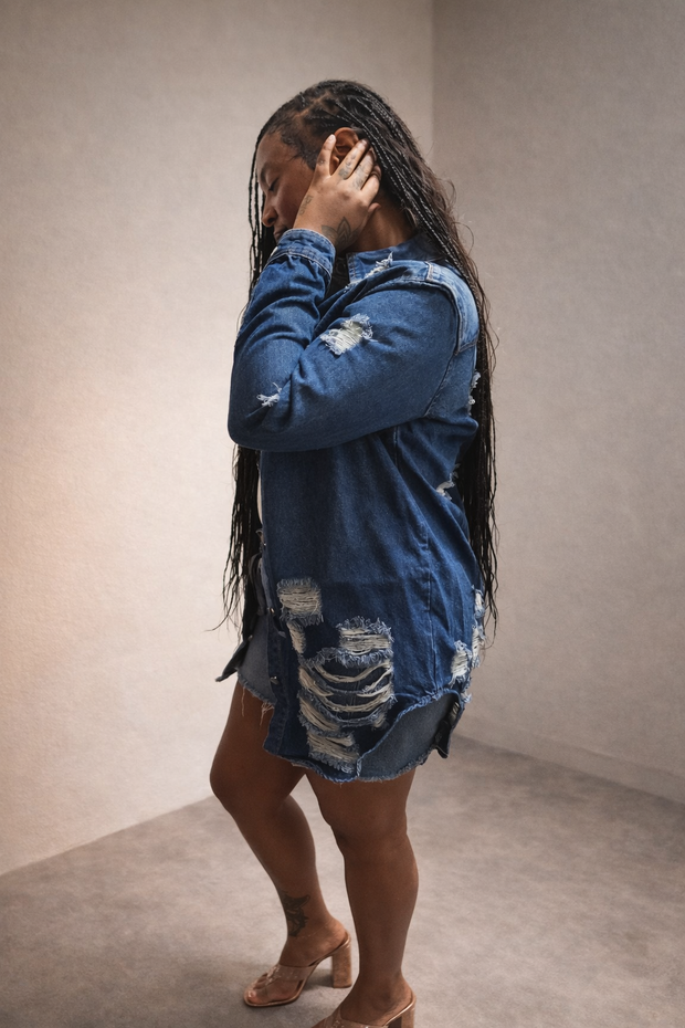 Side view of women’s distressed denim jacket with raw hem and ripped detailing
